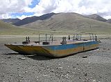 Tibet Kailash 04 Saga to Kailash 04 Ferry Lying Next to Bridge Across Yarlung Tsangpo The retired double-pontooned ferry sits idly on the north shore of the Yarlung Tsangpo. It used to hold two Land cruisers and one truck. The new bridge makes the river crossing, well, fast, but far less interesting.